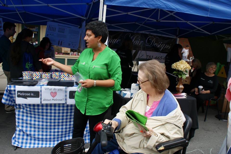 Picture of Manisha getting input on the Melrose Forward vision from a fairgoer.